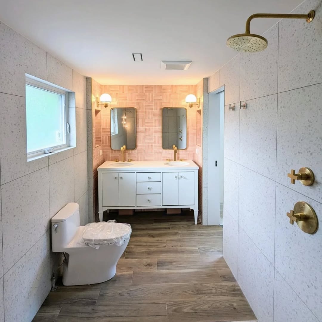 Built-in soaker tub with brass framed pink zellige niche and terrazzo surround Toronto
