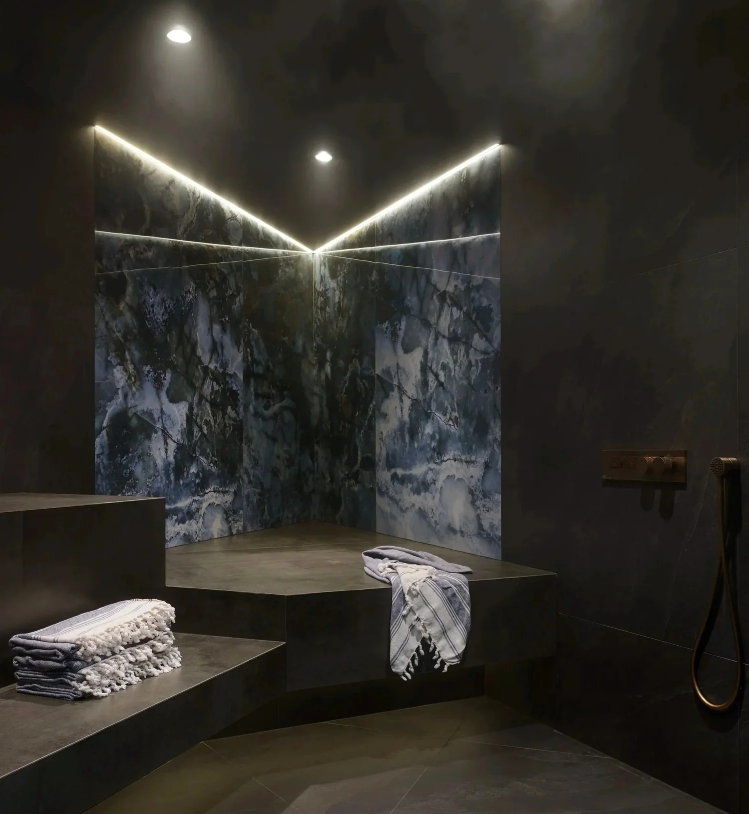 Hammam steam room with book-matched marble feature wall and LED cove lighting Toronto